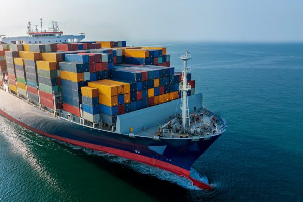 Aerial side view of cargo ship carrying container and running for export goods from cargo